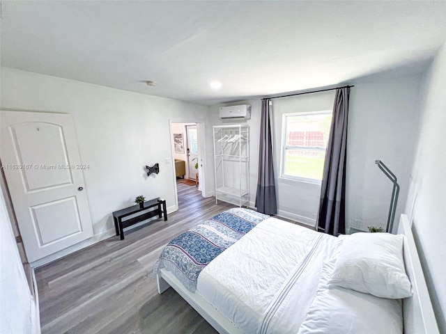 bedroom featuring a wall mounted AC and wood-type flooring