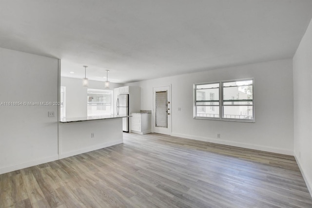 unfurnished living room with wood-type flooring