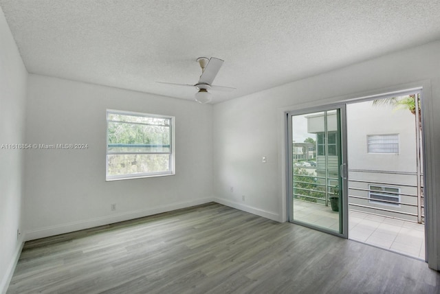 empty room featuring hardwood / wood-style flooring, a textured ceiling, and ceiling fan