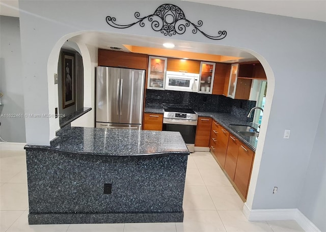 kitchen featuring light tile patterned flooring, appliances with stainless steel finishes, sink, and decorative backsplash