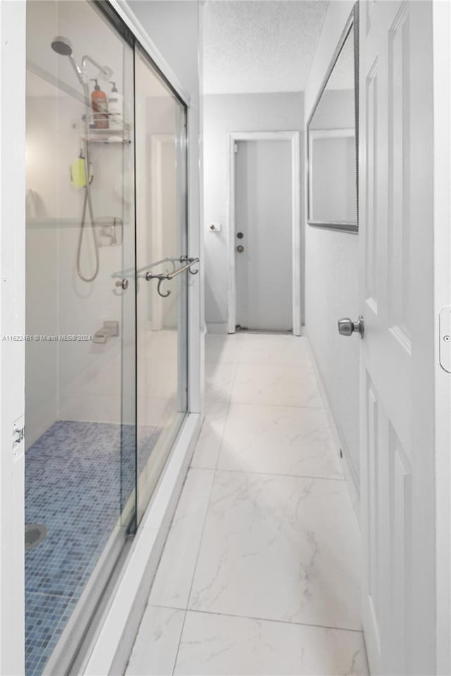 bathroom with tile patterned flooring and a textured ceiling