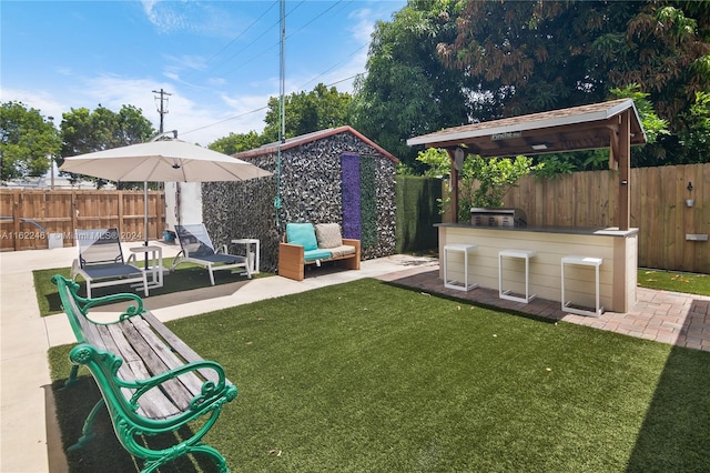 view of yard with outdoor lounge area, an outdoor bar, and a patio area