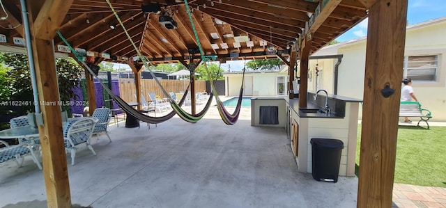 view of patio featuring sink and a fenced in pool