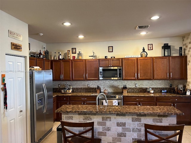 kitchen featuring a kitchen bar, tasteful backsplash, and stainless steel appliances