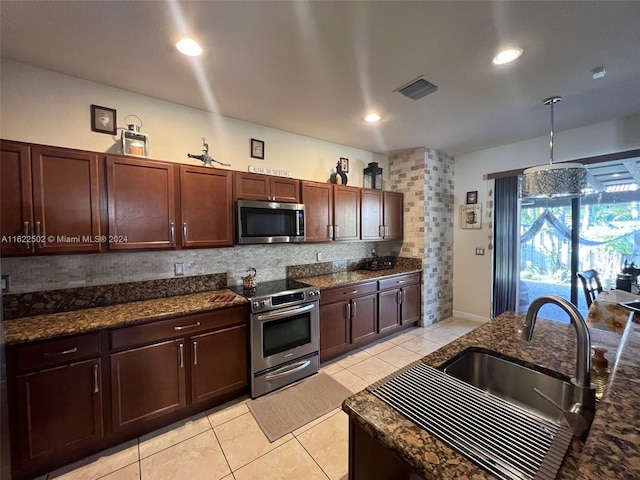 kitchen featuring light tile patterned flooring, stainless steel appliances, decorative backsplash, pendant lighting, and sink