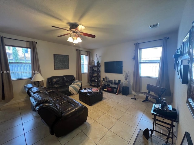 living room featuring ceiling fan, a wealth of natural light, and light tile patterned floors