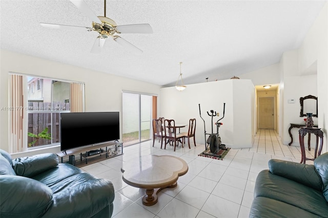 living room with light tile patterned flooring, ceiling fan, vaulted ceiling, and a wealth of natural light