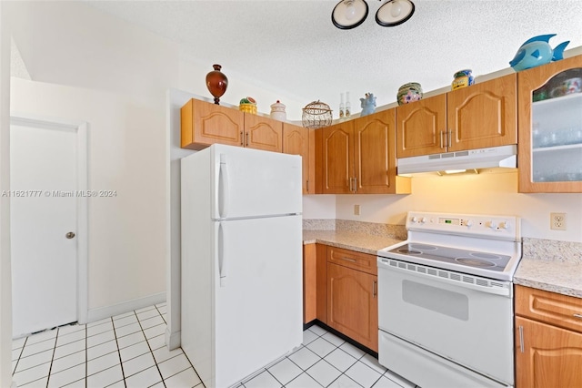 kitchen with light tile patterned flooring, light stone counters, a textured ceiling, and white appliances