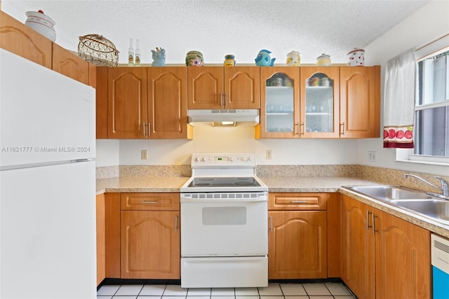 kitchen with light tile patterned flooring, sink, a textured ceiling, and white appliances