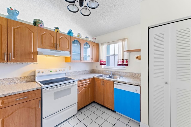 kitchen with electric stove, sink, light tile patterned floors, a textured ceiling, and dishwasher