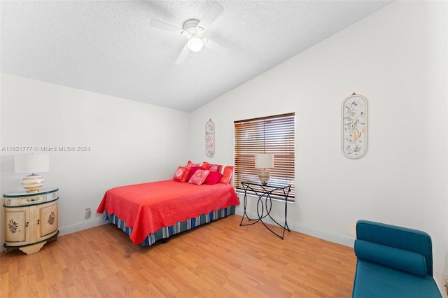 bedroom featuring light hardwood / wood-style floors, lofted ceiling, ceiling fan, and a textured ceiling