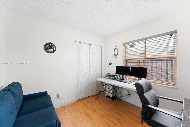 home office featuring a textured ceiling and light hardwood / wood-style flooring