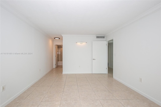 tiled spare room with crown molding