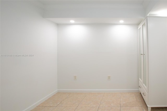 spare room with light tile patterned flooring and crown molding