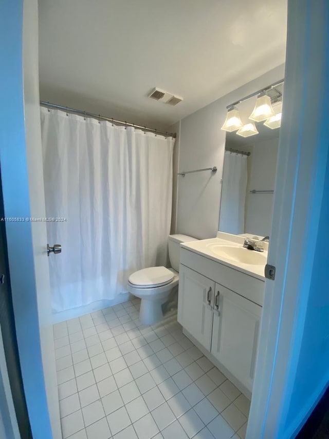 bathroom featuring vanity, tile patterned flooring, and toilet