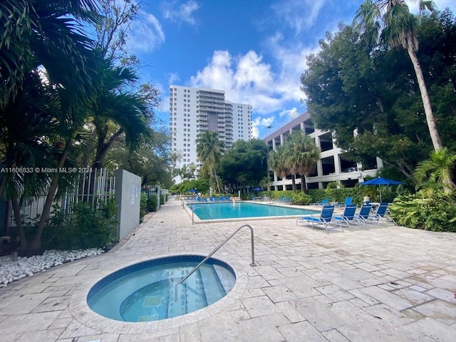 view of swimming pool featuring a community hot tub and a patio area