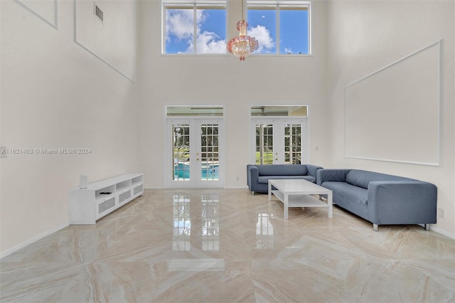 living room with a high ceiling, french doors, and tile patterned floors