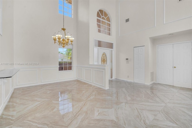 empty room featuring a high ceiling and a notable chandelier