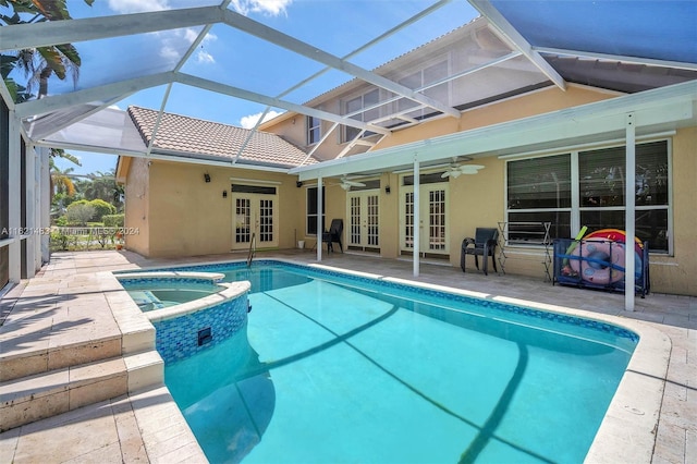 view of swimming pool featuring an in ground hot tub, french doors, a patio area, ceiling fan, and glass enclosure