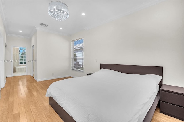 bedroom featuring crown molding, light hardwood / wood-style flooring, connected bathroom, and a notable chandelier