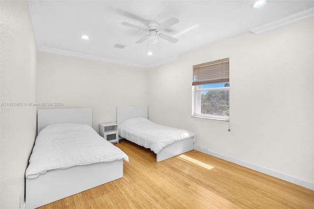 bedroom with ornamental molding, light wood-type flooring, and ceiling fan