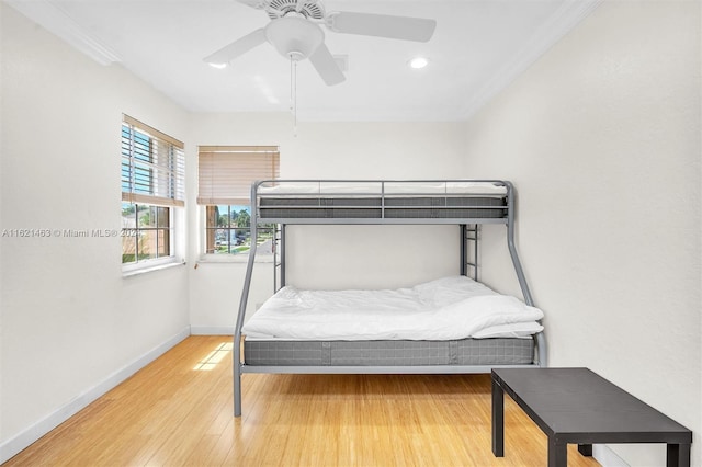 bedroom featuring hardwood / wood-style flooring, crown molding, and ceiling fan