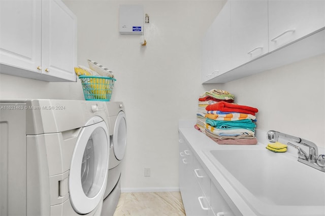 clothes washing area featuring sink, separate washer and dryer, cabinets, and light tile patterned floors