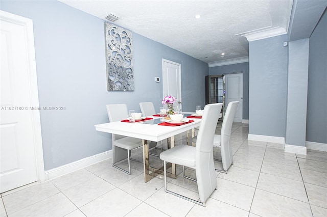 tiled dining area with a textured ceiling and crown molding