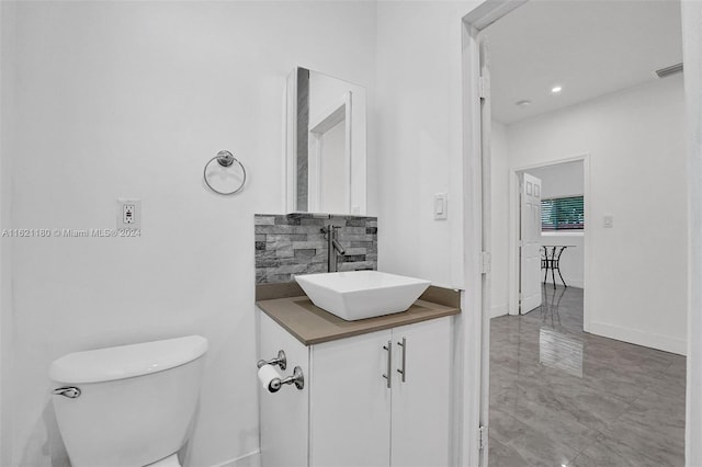 bathroom featuring backsplash, tile patterned floors, toilet, and vanity