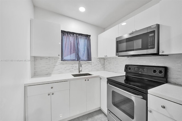 kitchen featuring white cabinetry, tasteful backsplash, stainless steel appliances, sink, and light tile patterned floors