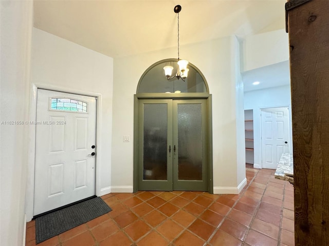 tiled entrance foyer featuring a notable chandelier