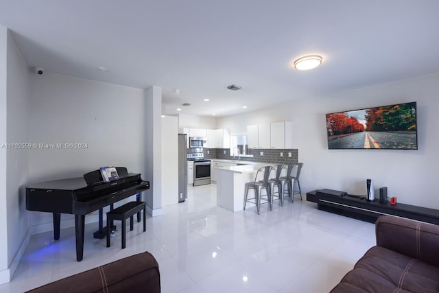 living room featuring sink and light tile patterned floors