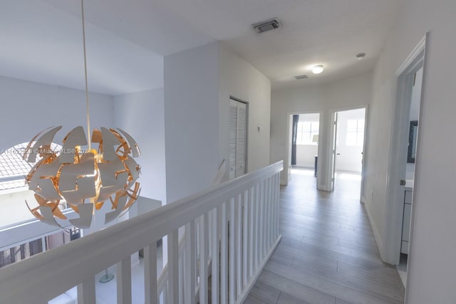 hallway with a notable chandelier and light hardwood / wood-style flooring