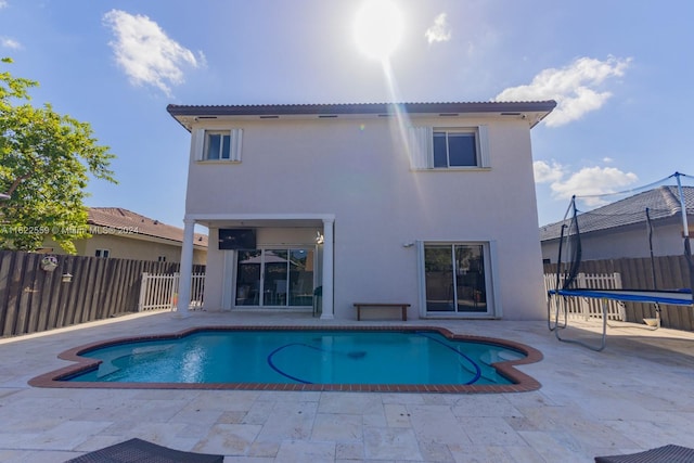 view of swimming pool featuring a patio and a trampoline