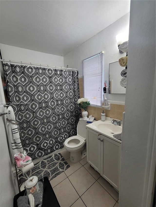 bathroom with toilet, vanity, and tile patterned floors