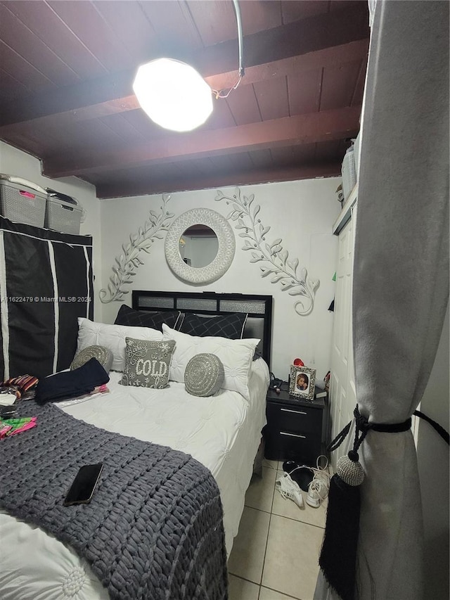 bedroom with wooden ceiling, light tile patterned floors, and beam ceiling