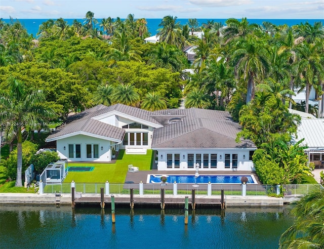 back of house featuring a patio area, a water view, a lawn, and a fenced backyard