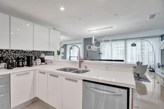 kitchen featuring kitchen peninsula, dishwasher, white cabinets, and sink