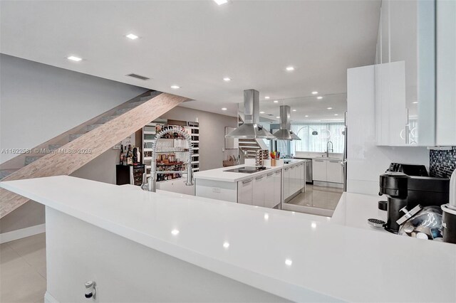 kitchen featuring island exhaust hood, white cabinetry, a center island, and sink