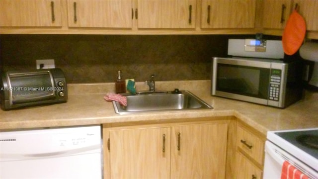 kitchen featuring sink, dishwasher, and light brown cabinetry