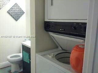 laundry area featuring stacked washer / dryer