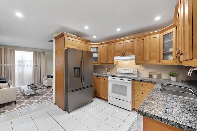 kitchen with light tile patterned floors, sink, white electric stove, and stainless steel fridge