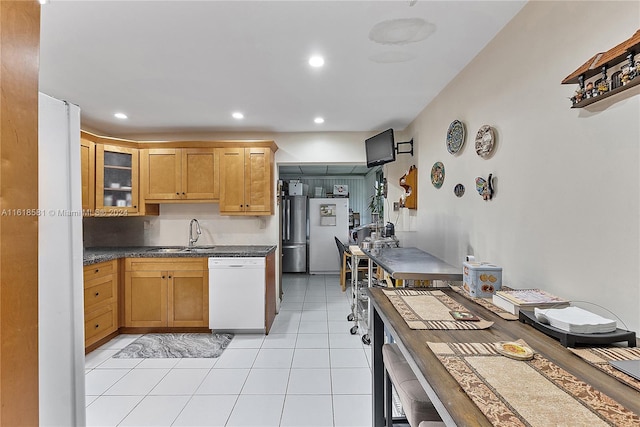 kitchen with light tile patterned flooring, sink, and white appliances