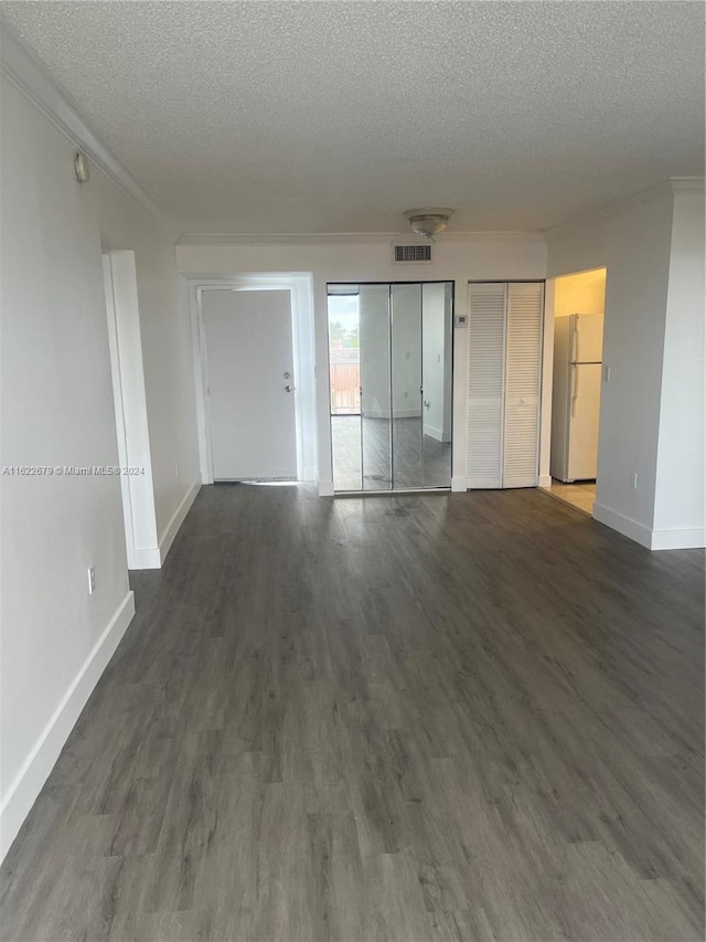 unfurnished room featuring crown molding, dark wood-type flooring, and a textured ceiling