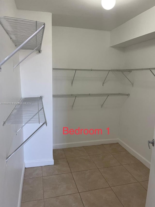 spacious closet with light tile patterned floors