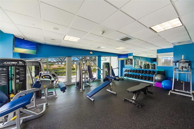 workout area featuring a drop ceiling and a healthy amount of sunlight