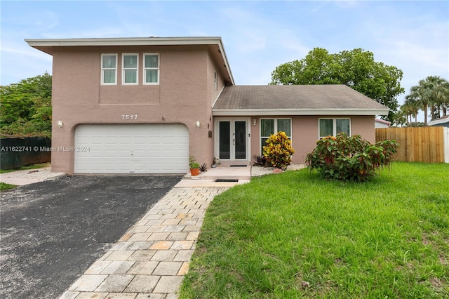 view of front of house with a garage and a front lawn