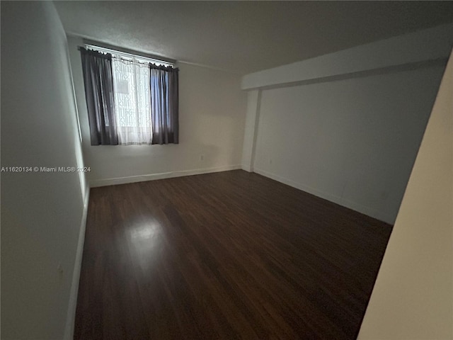 empty room featuring dark hardwood / wood-style flooring