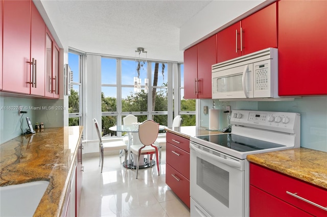 kitchen featuring light stone counters, decorative light fixtures, a textured ceiling, light tile patterned floors, and white appliances