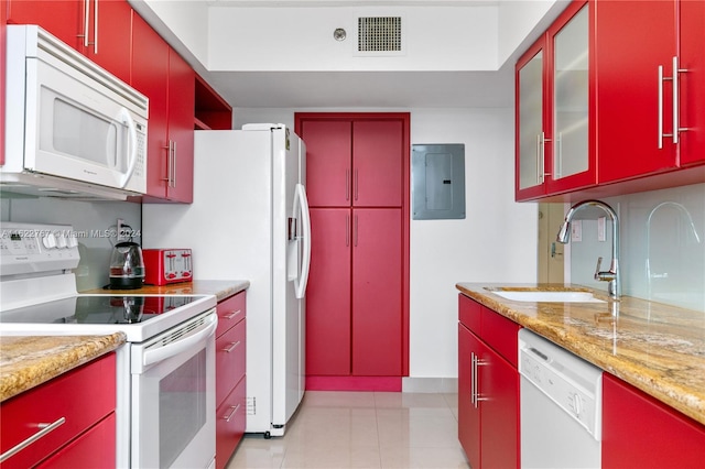 kitchen with sink, light stone counters, electric panel, and white appliances